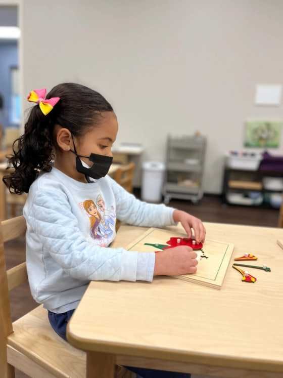 Kindergarten-aged student working on a puzzle. 