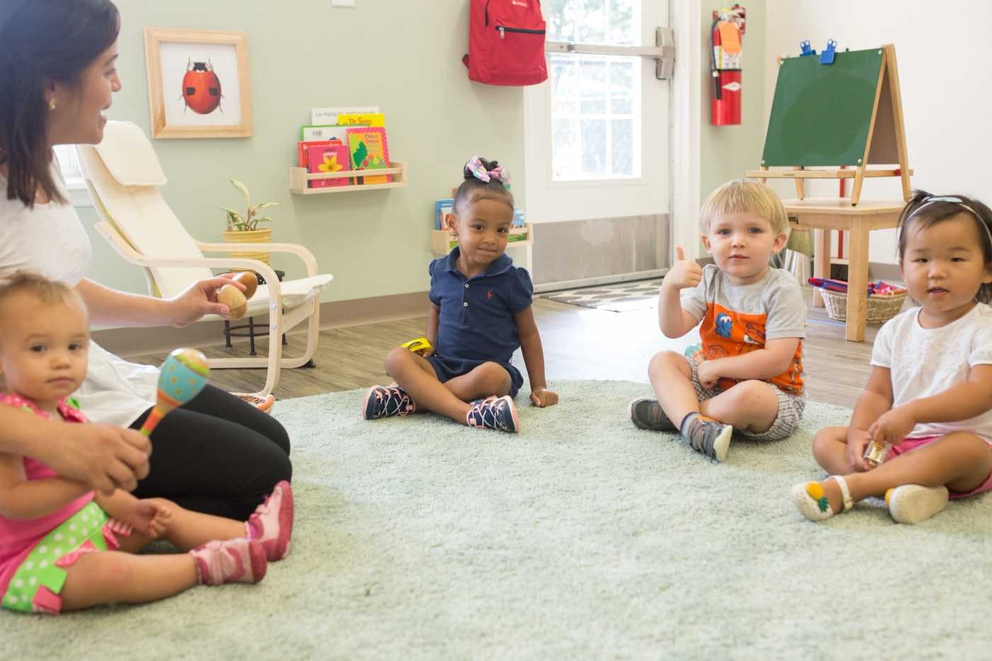 children sitting on the floor at guidepost montessori learning with their guide