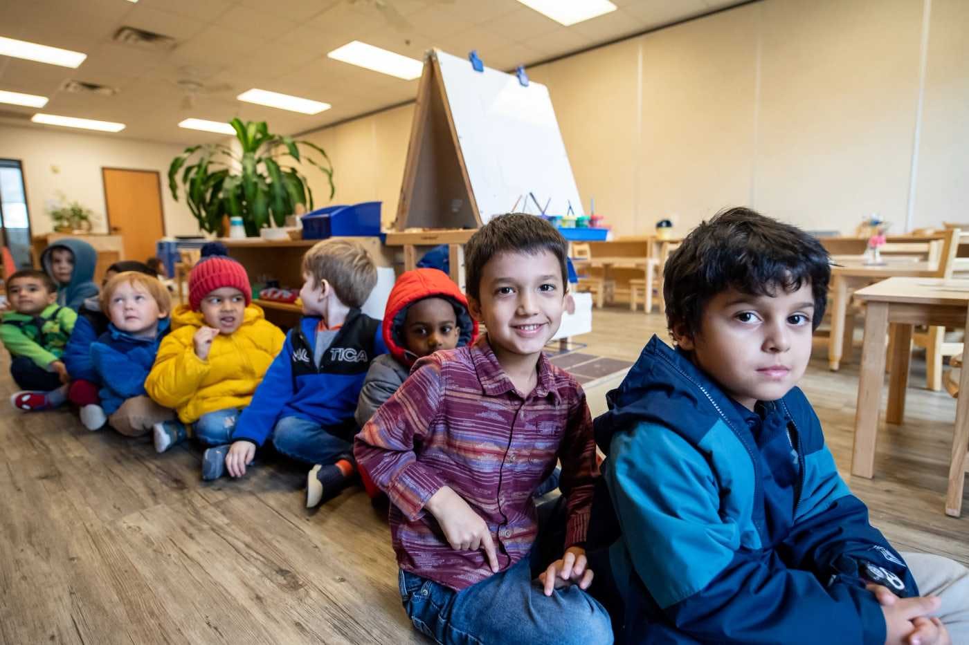 children at guidepost montessori sitting in a row smiling