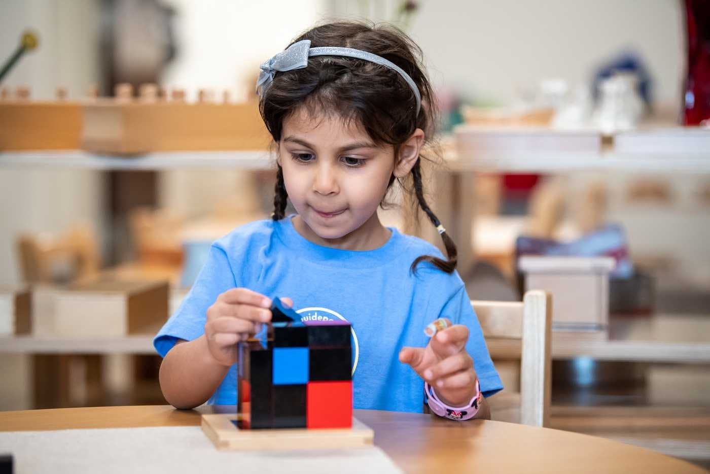 child at guidepost montessori building with colorful blocks at a table